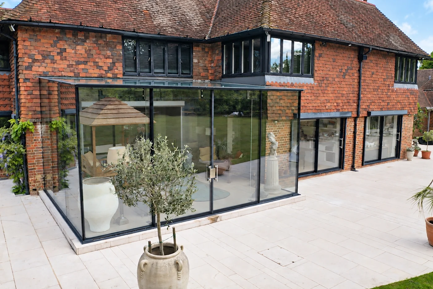Southcroft glass extension beside a tiled house and stone terrace, digitally enhanced photograph